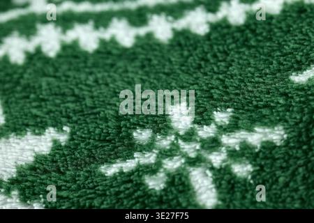 Detailed macro of fluffy fleece material featuring a festive green and white pattern and soft pile Stock Photo