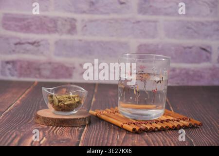 Hot water with cardamon sits on a wooden table Stock Photo