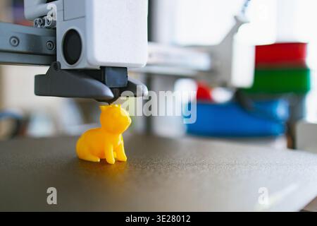 3D Printer Creating Yellow Cat Figurine Stock Photo