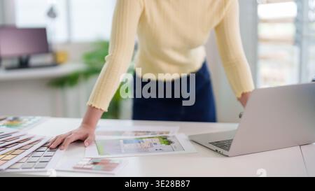 Adult architect or interior designer reviewing blueprints and material samples. A creative professional works on a new project in a bright contemporar Stock Photo