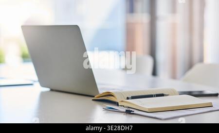 Empty, desk and laptop with notebook in office for research notes, journalism schedule and to do list. Journal, tech and paperwork at publishing Stock Photo