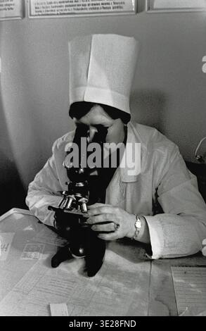 Slavyansk, Slaviansk, Sloviansk, Slovyansk, AIZ hospital, 1982, USSR, Soviet Union, medicine, healthcare, medical worker, orderly, nurse, laboratory assistant, washing, cleaning, glassware, test tubes, sink, tap water, hygiene, sanitation, hospital, clinic, medical facility, workplace, female, uniform, white coat, authentic, vintage, retro, black and white, archival, history, historical, documentary, daily life, occupational labor, manual labor, medical history, era, peaceful, health standards, medical preparation, everyday life, working class, sanitary routine. Stock Photo