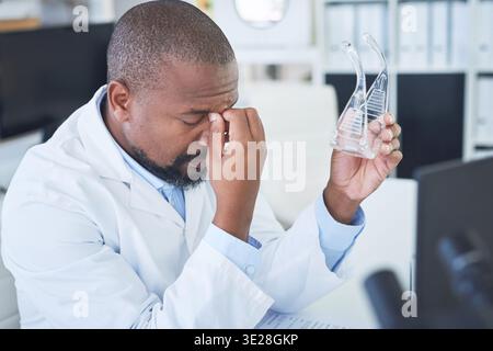 Scientist, man or goggles with headache in lab for experiment fail, research burnout or workload. Medical innovation, mature black person or stress Stock Photo