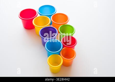 High Angle View of Nesting Stacking Cups in Vibrant Colors Isolated on White Stock Photo