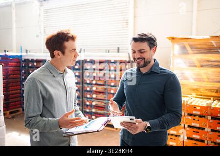 Warehouse managers collaborating on inventory using digital tablet Stock Photo