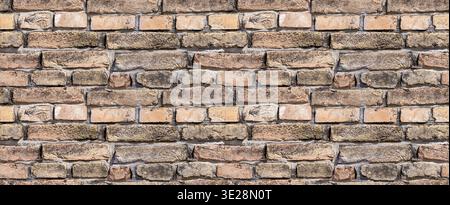 Rustic, aged brick wall texture. A seamless background featuring weathered brown and red bricks with dark mortar Stock Photo