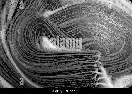 White foam on black pan surface, dishwashing concept, close up  texture Stock Photo