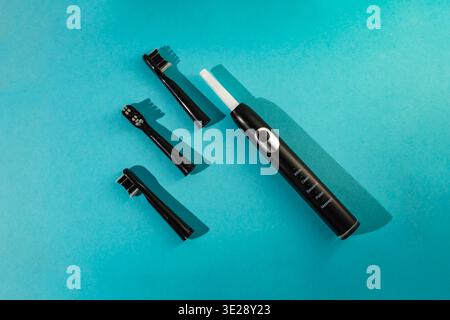 Pulse electric toothbrush with exchange heads on blue background, flat lay Stock Photo