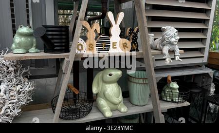 Decorative Easter-themed display featuring ceramic bunnies, a frog and various garden accessories Stock Photo