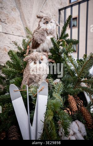 Plush owl ornaments on winter evergreens with skis in Zermatt Stock Photo