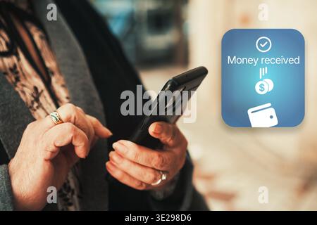 Mobile payment notification on smartphone screen. Woman hands using online banking app. Digital finance and money transfer concept. Stock Photo