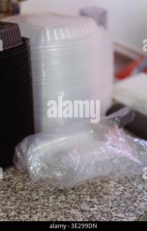 Stacked Containers Bubble Wrap On Counter, Black And White Lids And Trays On Granite Surface, Stock Photo