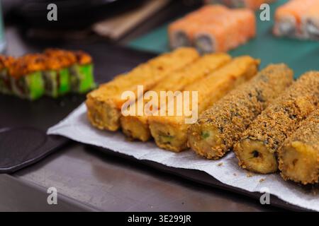 Crispy Fried Sushi Fingers On Paper Tray With Golden Crumb Coating, Batch Cooling Next To Fresh Stock Photo
