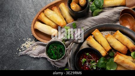 Crispy spring rolls with vegetables for appetizer on a dark background. Asian snack concept. Top view. Stock Photo