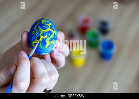 Woman is painting eggs preparing for Easter.  Stock Photo