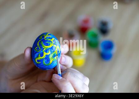 Woman is painting eggs preparing for Easter.  Stock Photo