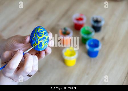 Woman is painting eggs preparing for Easter.  Stock Photo