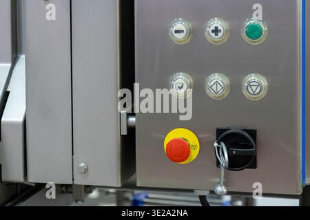 A close-up shot captures the intricate details of a modern industrial control panel, showcasing a variety of illuminated push buttons, including a pro Stock Photo