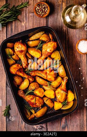 Roasted chicken legs with potatoes and rosemary. Top view. Stock Photo