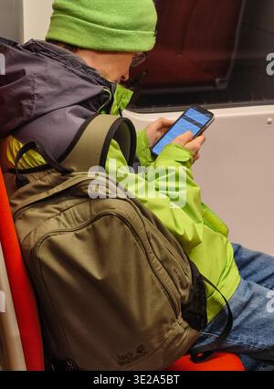 Prague, Czech Republic - March 19, 2026: Inside a Prague metro train carriage. Commuters and passengers sitting and using their smartphones during commute. Stock Photo