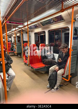 Prague, Czech Republic - March 19, 2026: Inside a Prague metro train carriage. Commuters and passengers sitting and using their smartphones during commute. Stock Photo