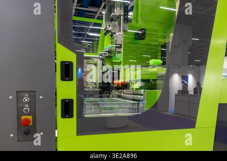 Helsinki, Finland - March 11, 2026: A cutting-edge lime green industrial manufacturing machine, an injection molding system, is showcased at an exhibi Stock Photo