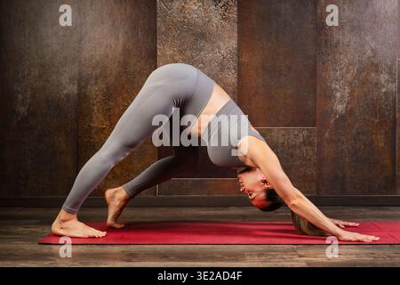 Pregnant woman practicing prenatal yoga down dog pose Stock Photo