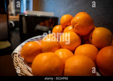Wicker basket of dewy oranges in boutique hotel, Zermatt, Switzerland Stock Photo