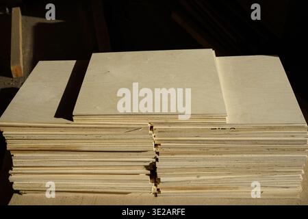 Stacks of plywood sheets on a wooden pallet in a workshop Stock Photo