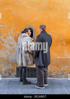A couple buying a glass of wine from a wine window at Babae ,a restaurant /bar on Via Santo Spirito in the Oltrano district of Florence,Italy Stock Photo