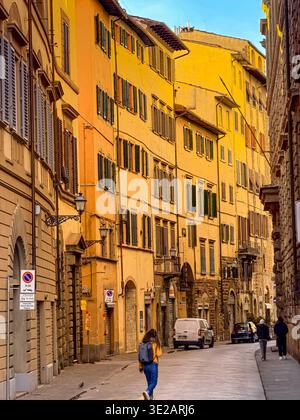 A woman walking along Piazza di San Firenze in the early morning winter sunshine in Florence ,Italy Stock Photo