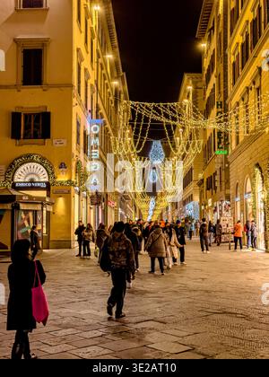 Christmas time in Florence with people walking along Via dei Calzaiuoli  under the Christmas lights and decorations in in Florence,Italy Stock Photo
