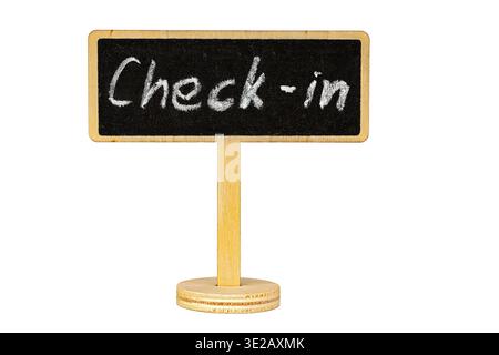 A charming handwritten chalk Check-In sign written on a small blackboard mounted on a round wooden stand, isolated on a clean white background with co Stock Photo