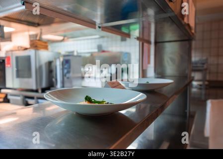 Plated dishes on stainless pass in Oberlech Austria hotel kitchen Stock Photo