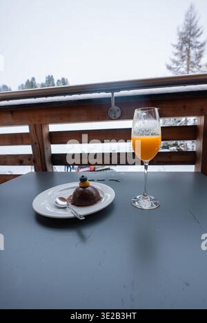 Chocolate mousse dome and orange juice on terrace in Oberlech, Austria Stock Photo