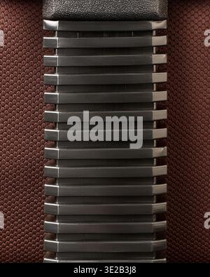 black ribbed plastic slats of a chair on dark brown fabric background, horizontal parallel lines with matte finish, concept of industrial material Stock Photo