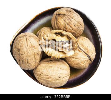 Top view of shelled and whole walnuts in ceramic bowl isolated on white background Stock Photo
