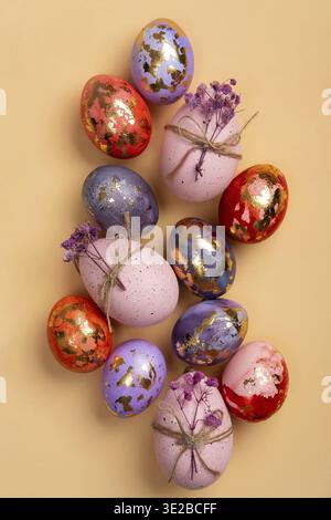 Happy Easter day! ?omposition with modern Easter eggs with gold decorations and spring flowers on beige background. Easter holiday background with sty Stock Photo