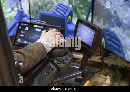 Berlin, Germany - January 22, 2024: Operator is using advanced machinery control panel with multiple screens displaying operational data Stock Photo