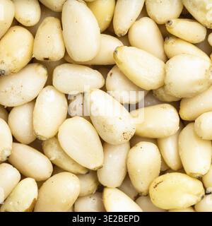Square food background - shelled pine nuts close up Stock Photo