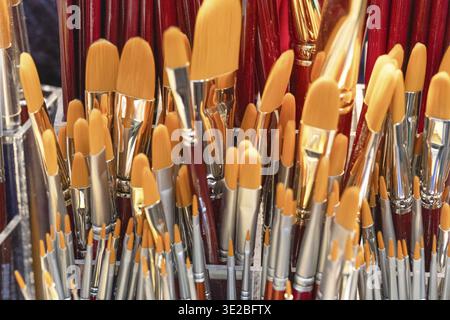 A vibrant collection of paintbrushes featuring orange bristles, displayed together, showcasing artistic tools for creativity and inspiration Stock Photo