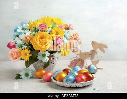 Easter eggs, easter rabbit and spring flowers, space for text. Happy Easter. Congratulatory easter background Stock Photo