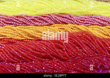 Strands of beads in various bright colors are beautifully arranged, showcasing textures and patterns ideal for creative projects Stock Photo