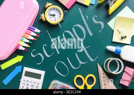Phrase School's Out and school supplies on chalkboard, flat lay Stock Photo