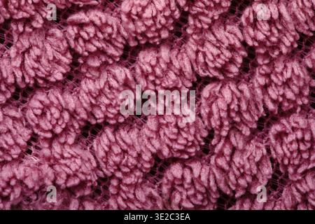 Detailed macro of pink yarn with intricate looped texture, ideal for backgrounds, crafts, and textile design concepts. Stock Photo