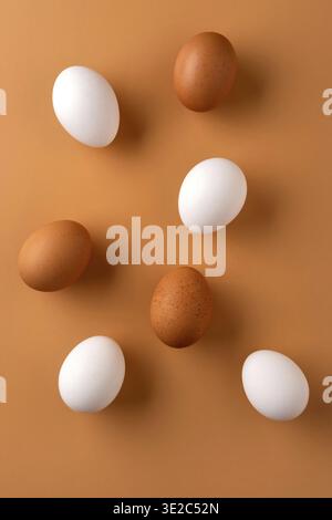Brown and white chicken egges on beige background. Chicken eggs on the table. Fresh eggs on breakfast Stock Photo