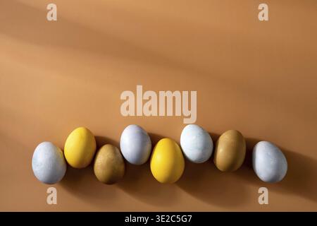 Naturally dyed easter eggs on beige background. Eco concept. Organic natural easter concept. Modern easter eggs painted with natural dye in different Stock Photo
