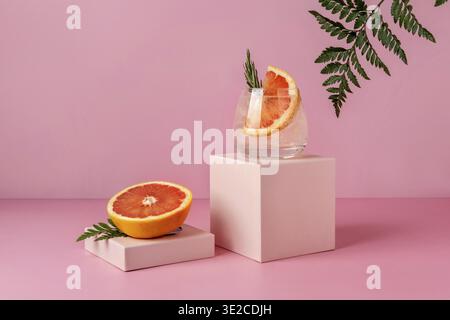 Refreshing colorful summer drink with grapefruit on pink background with shadow fern. Paloma cocktail Stock Photo