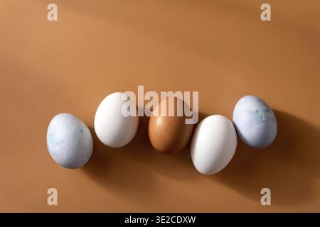 Naturally dyed easter eggs on beige background. Eco concept. Organic natural easter concept. Modern easter eggs painted with natural dye in different Stock Photo