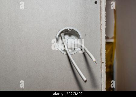 Electrical box with wiring inside new drywall in a construction project Stock Photo